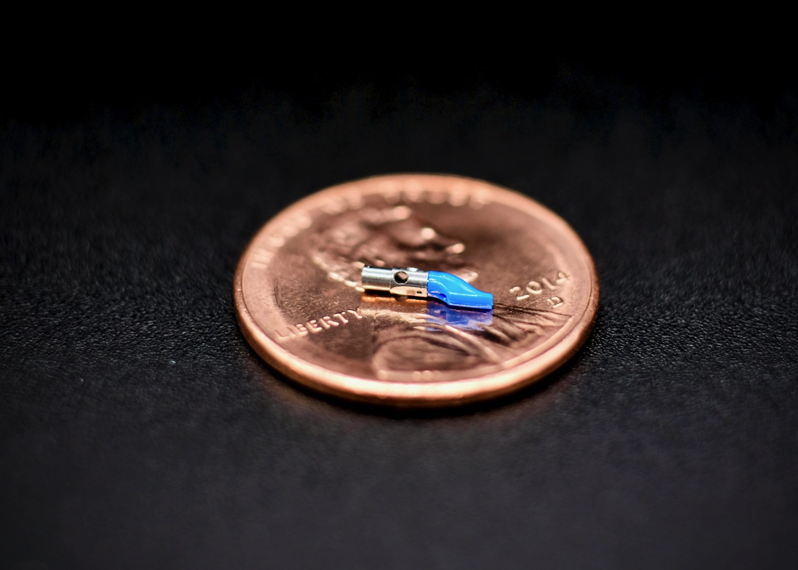 A penny with a blue piece of plastic on it.