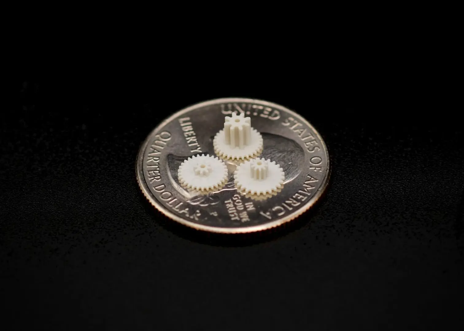 A coin with three white gears on it.