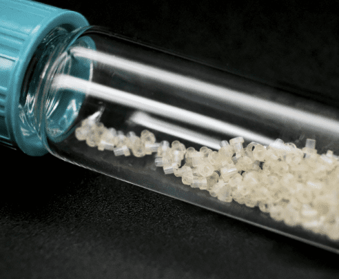 A glass tube filled with white rice sitting on top of a table.